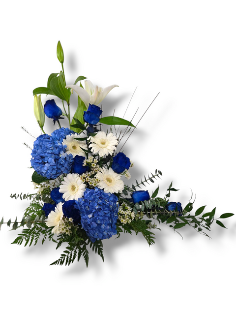 Arrangement funéraire de fleurs bleues et blanches avec roses, hortensias, lys et marguerites