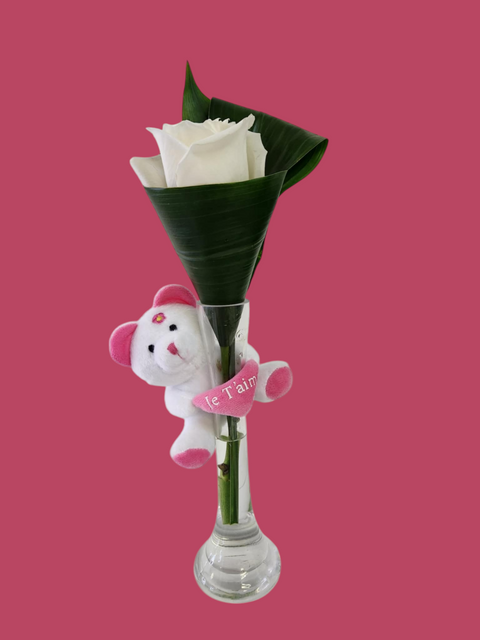 Rose blanche en cône de feuillage avec peluche rose « Je t’aime » dans un vase étroit – cadeau doux et romantique.