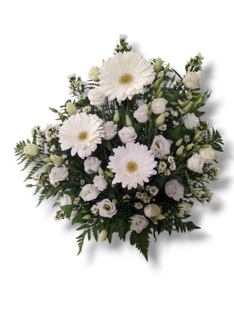 Arrangement funéraire blanc avec gerberas, lisianthus, petites marguerites et feuillage – composition paisible et élégante.