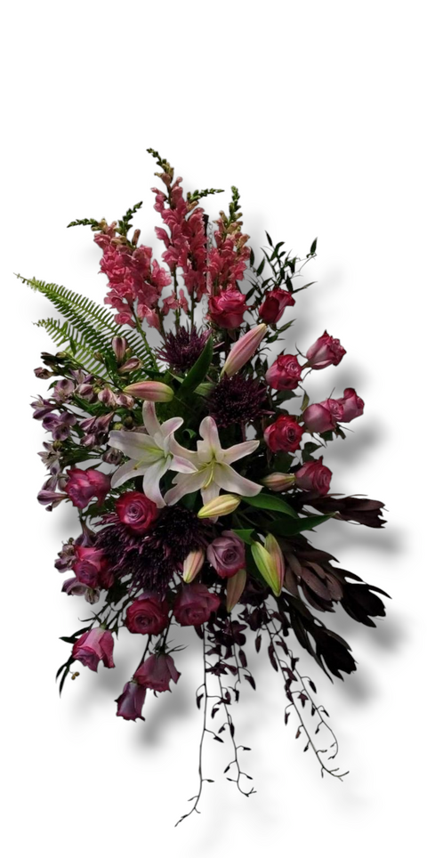 Arrangement funéraire vertical avec roses bourgogne, lys blancs, fleurs mauves, mufliers et verdure – modèle Souvenir Majestueux.