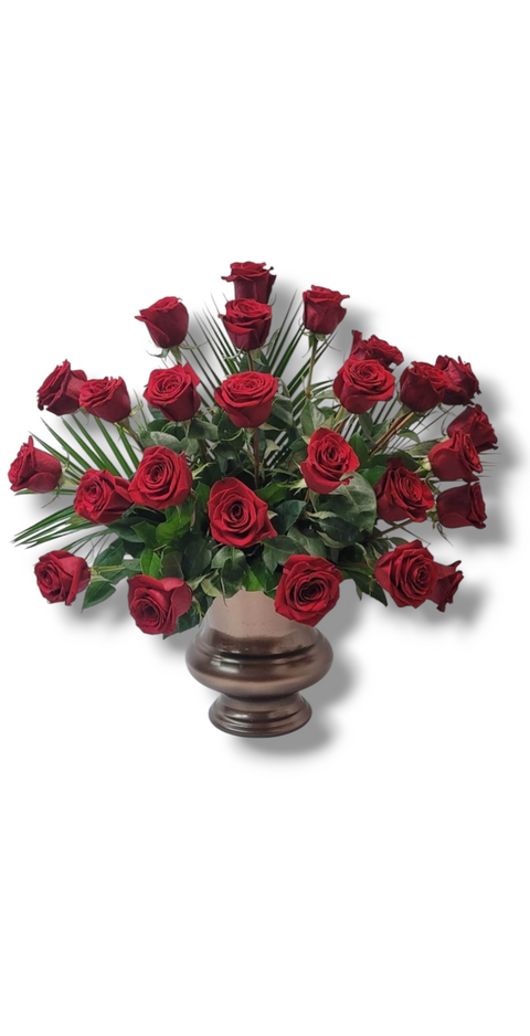 Arrangement funéraire de 24 roses rouges avec feuillage et palmes, dans un vase foncé – modèle Amour Solennel.