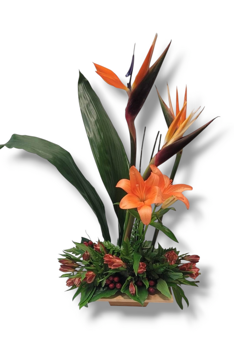Arrangement floral exotique avec oiseaux du paradis, lys orange, feuillage tropical et fleurs de saison – modèle Soleil Tropical.