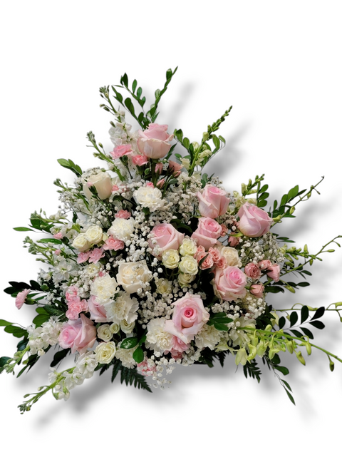 Arrangement funéraire Douce Sympathie avec roses roses pâles, œillets blancs et gypsophile.