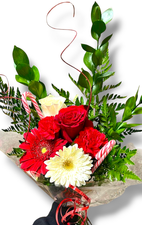 Bouquet de Noël avec roses rouges et blanches, gerberas, feuillage et cannes de bonbon – modèle « Douceur de Noël » par Fleur de Guy.