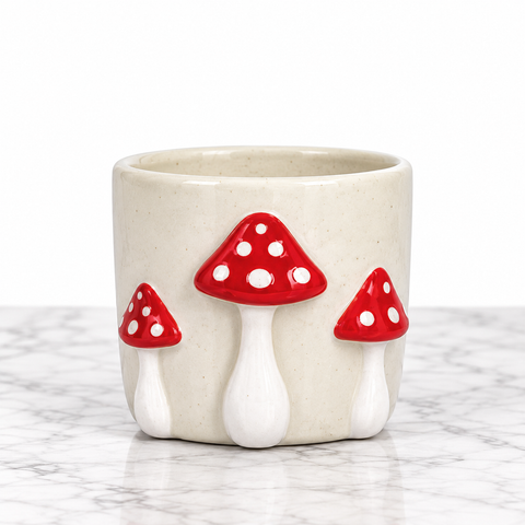 Cache-pot crème de 4 pouces décoré de trois champignons rouges à pois blancs en relief.