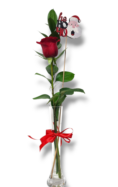 Rose rouge avec verdure dans un vase étroit décoré d’un ruban et d’un petit Père Noël – arrangement « Ho Ho Rose » de Fleur de Guy.