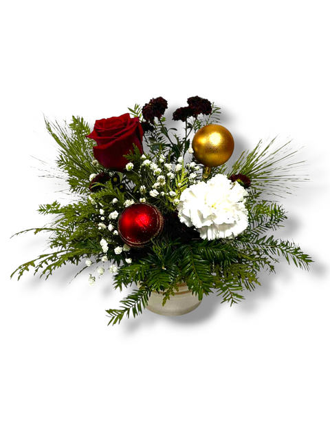 Petit arrangement floral de Noël avec rose rouge, œillet blanc, gypsophile, feuillage et boules décoratives – modèle « Noël Classique » par Fleur de Guy.