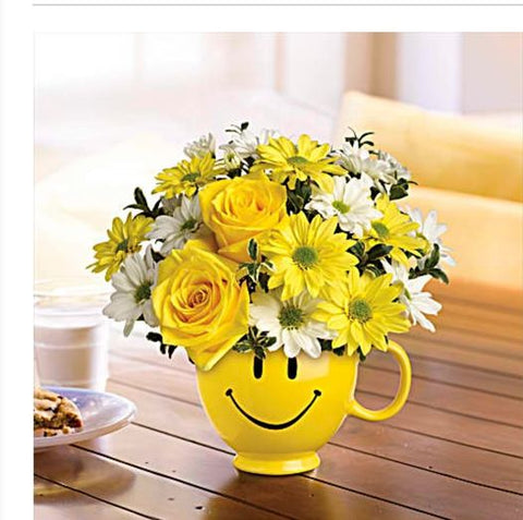 Bouquet de roses jaunes et marguerites dans une tasse jaune souriante – modèle Sourire en Fleurs.