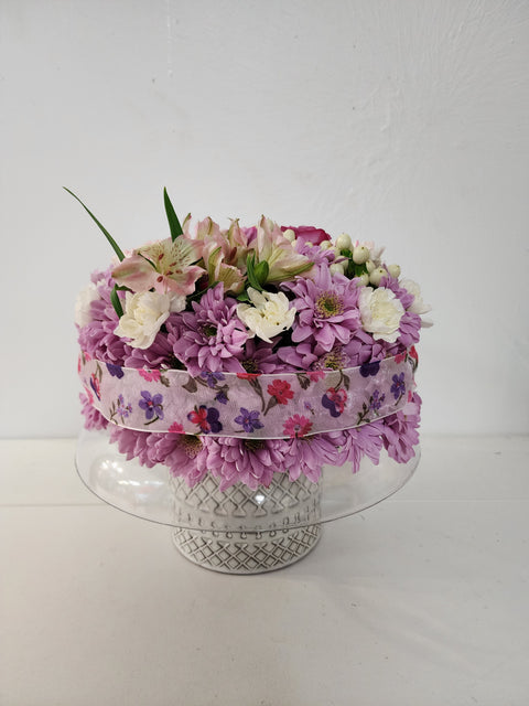 Gâteau floral avec marguerites mauves, œillets blancs, alstroemerias roses et ruban fleuri – idée originale et festive.