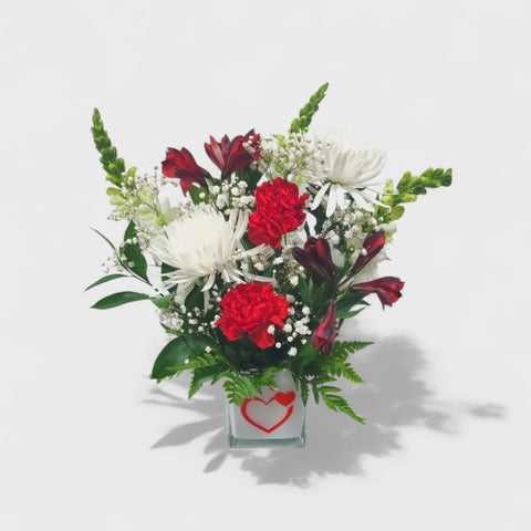 Arrangement floral Saint-Valentin rouge et blanc dans un vase avec cœur