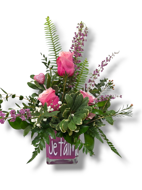 Arrangement floral avec roses roses et feuillage dans vase Je t’aime
